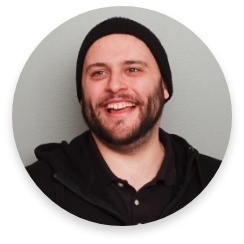 Photo de profil d'un homme barbu souriant avec une tuque sur la tête